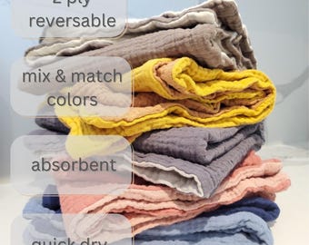 May include: A stack of reversible, absorbent, quick-dry washcloths in various colors, including yellow, gray, pink, and blue. The washcloths are 2-ply and feature the text "mix & match colors".