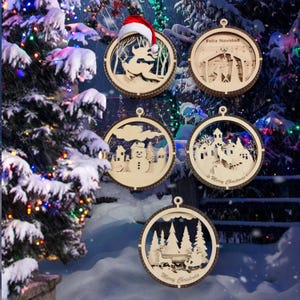 Può includere: Cinque addobbi natalizi in legno con diverse scene invernali. Gli addobbi sono rotondi e hanno un effetto 3D. Le scene includono un pupazzo di neve, una renna, una scena della natività, un villaggio invernale e una slitta con renne.