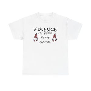 May include: White t-shirt featuring the message "VIOLENCE CAN NEVER BE THE ANSWER" in black. Two gnome illustrations with red and white hats flank the text. The shirt is made of a soft, comfortable material.