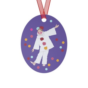 May include: A purple oval ornament with a white clown figure in a white and red costume. The clown is surrounded by colorful confetti.
