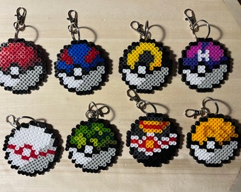 May include: Eight circular keychains crafted from small, fused plastic beads, each featuring a distinct spherical design inspired by various game balls. The keychains include red, blue, yellow, purple, green, and orange patterns with metal clasps.