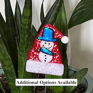 Könnte beinhalten: Ein farbenfroher Schneemann-Gartenstecker mit roter Mütze und blauem Schal. Der Schneemann hat einen weißen Körper mit schwarzen Augen und einer Knopfnase. Der Text "Additional Options Available" befindet sich unten.