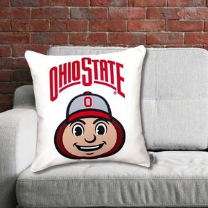 brutus buckeye pillow mascot styled on a gray sofa