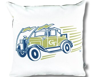 May include: A square white throw pillow featuring a graphic illustration of a vintage car in blue and gold. The car has lightning bolts above it and motion lines behind it, with the letters GT printed on the side door and a small TM symbol.