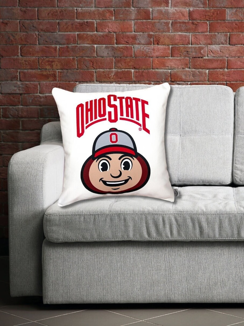 brutus buckeye pillow mascot styled on a gray sofa