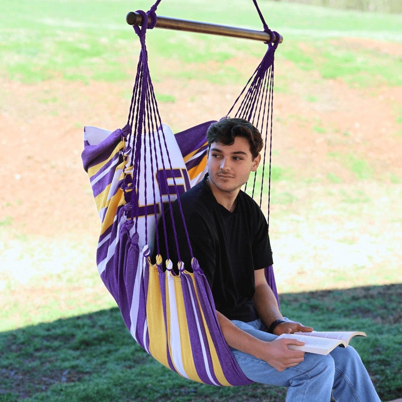 man sitting on a LSU hammock chair outdoors