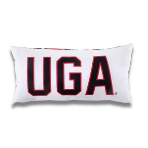 May include: White rectangular pillow with the letters "UGA" in large black block letters with red outlines. The pillow is a decorative item, likely for a bed or couch. The pillow has a white background.
