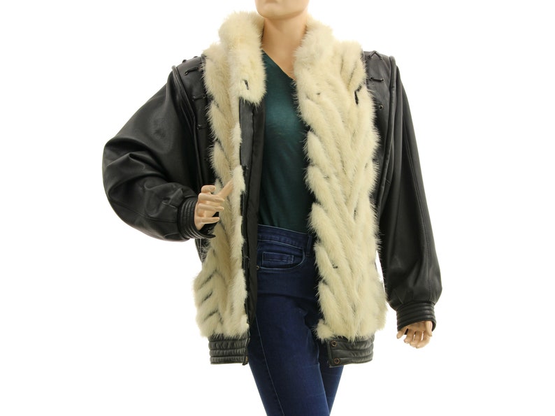 May include: A black leather jacket with a white fur collar and lining. The jacket has a zipper closure and a stand-up collar.