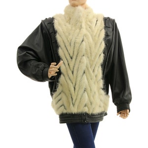 May include: A black leather jacket with a white fur panel down the front. The fur is arranged in a chevron pattern.