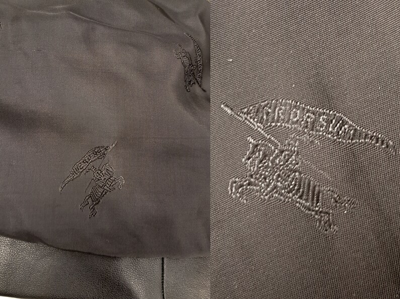 May include: Close-up of a black fabric with a repeated embroidered design of a knight riding a horse with a flag that says "BURBERRY".