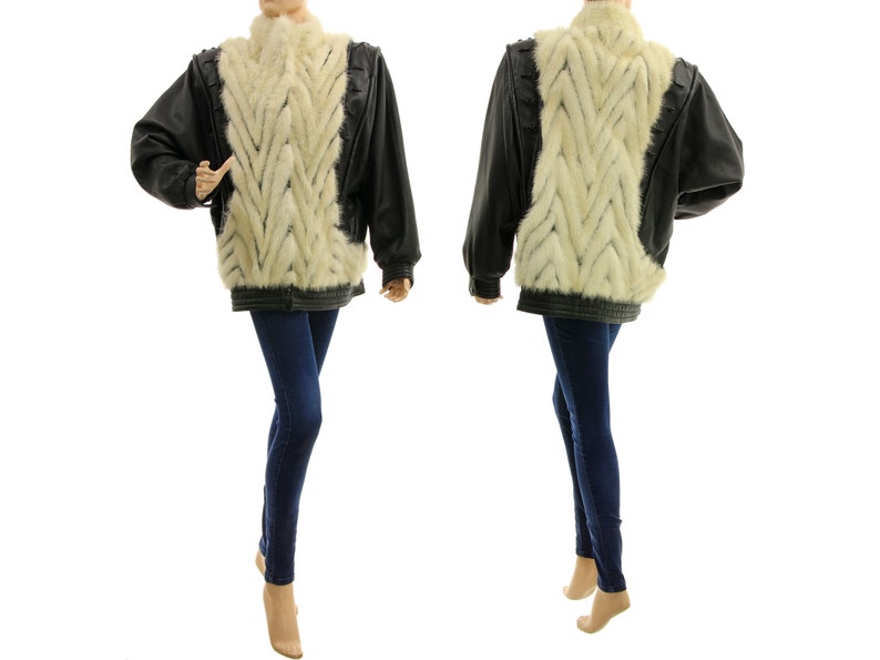 May include: A black leather jacket with a white fur panel down the back. The fur is in a braided pattern.