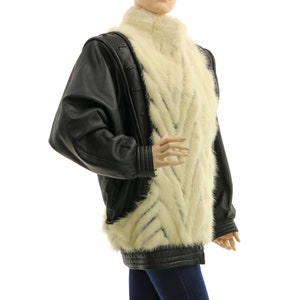 May include: A black leather jacket with a white fur collar and lining. The fur is arranged in a chevron pattern.