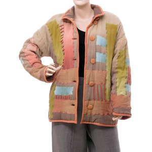 Könnte beinhalten: Eine Patchworkjacke mit verschiedenen Farben und Texturen, darunter Braun, Grün, Orange und Blau. Die Jacke hat einen Knopfverschluss und einen Kragen.
