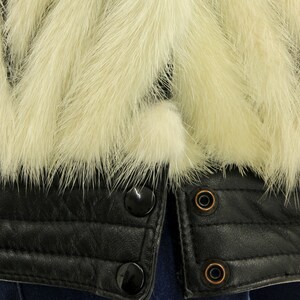 May include: A black leather jacket with a white fur collar. The jacket has a zipper closure and multiple snap buttons.