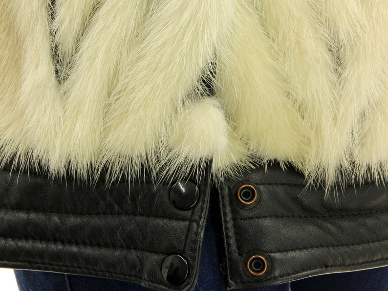 May include: A black leather jacket with a white fur collar. The jacket has a zipper closure and multiple snap buttons.