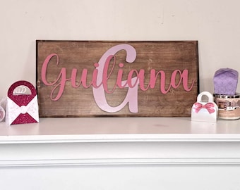 Signo de letra en relieve con nombre e inicial grande.