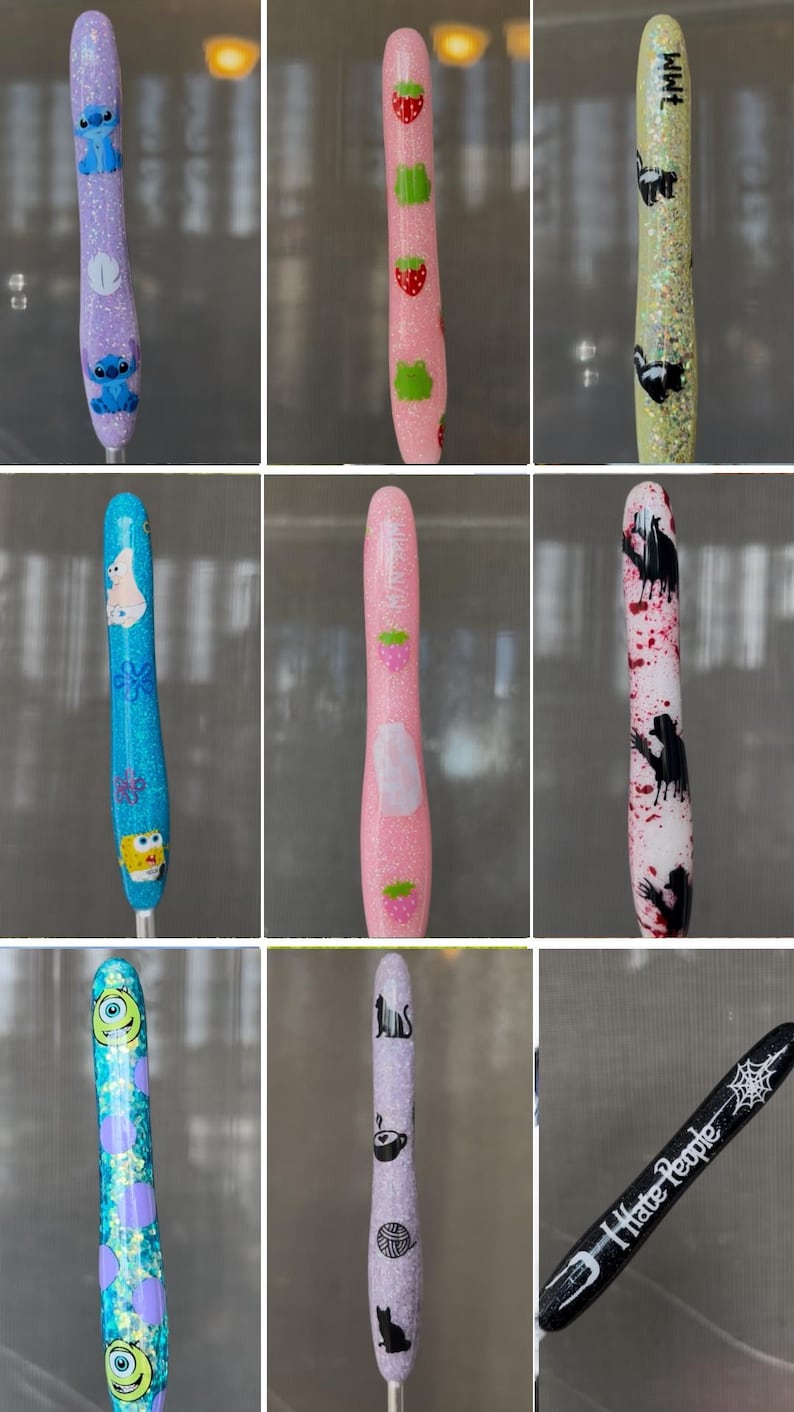 K&ouml;nnte beinhalten: Eine Sammlung glitzernder, dekorativer Stiftaufs&auml;tze mit verschiedenen Designs. Die Aufs&auml;tze zeigen Zeichentrickfiguren, Erdbeeren, Stinktiere und andere Grafiken. Einige Aufs&auml;tze haben Text, darunter "I hate people."