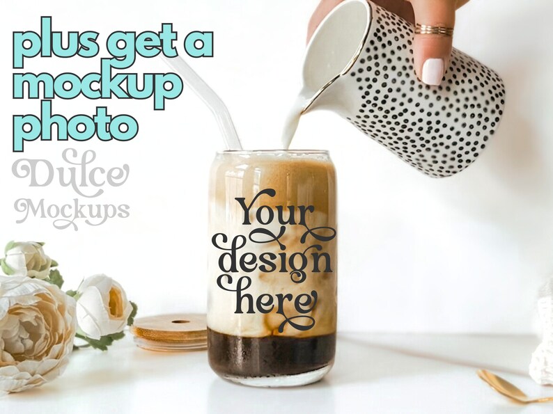 May include: A glass can with a black and white design that says "Your design here" is being filled with milk from a white jug with black polka dots. The can is sitting on a white surface with a wooden lid and white flowers.