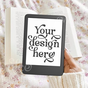 May include: A black and white e-reader with a white background and the text "Your design here" displayed on the screen.