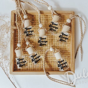 May include: Seven clear glass bottles with wooden tops and brown twine hanging from a wooden tray. Each bottle has a label that says "Your Design Here".