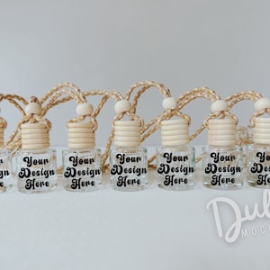 May include: Seven clear glass bottles with wooden tops and string hangers. Each bottle has a label that says "Your Design Here".