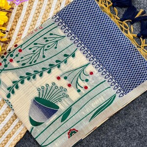 Floral linen saree pastel color Indian saree
Designer saree with printed pallu tassels
Soft cotton linen saree elegant floral design
Traditional Indian saree modern pastel style
Lightweight festive saree with blouse piece