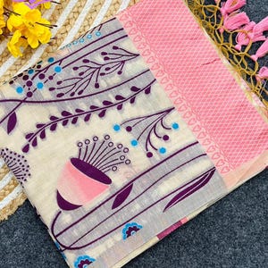 Floral linen saree pastel color Indian saree
Designer saree with printed pallu tassels
Soft cotton linen saree elegant floral design
Traditional Indian saree modern pastel style
Lightweight festive saree with blouse piece