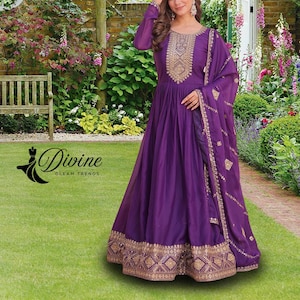 May include: A long, flowing purple dress with gold embroidery on the bodice, sleeves, and hem. The dress features a matching purple scarf with gold detailing. The image includes the text "Divine Gleam Trends".