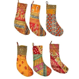 May include: Six colorful Christmas stockings with various patterns. The stockings feature a mix of red, orange, yellow, and green fabrics with floral and geometric designs. Each stocking has a loop for hanging.