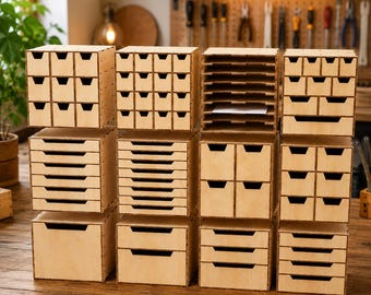 May include: A modular wooden storage system consisting of multiple stacked units with various drawer configurations, including small square compartments, horizontal letter trays, and larger deep drawers, all crafted from light-colored plywood.
