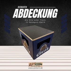 Könnte beinhalten: Ein blauer Bierkasten mit einer Holzplatte, beschriftet mit "Goller" und "Bierkasten Abdeckung". Der Kasten dient als Sitz oder Tisch mit einem sechseckigen Muster auf der Oberseite.