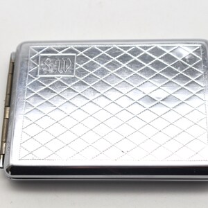 Elegant silverfärgat cigarettfodral i 60-talsstil med ett elegant krommönster