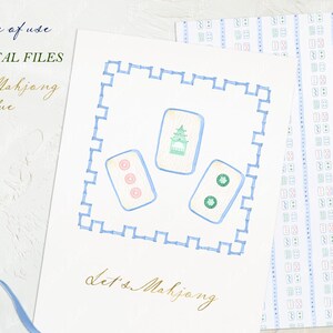 May include: A white card with a blue border and a blue and green illustration of mahjong tiles. The text "Let's Mahjong" is written in gold script on the card.