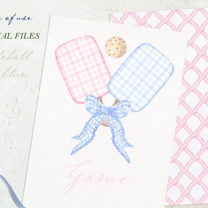 May include: A digital file for a DIY pickleball game. The image shows two watercolour paddles, one pink and one blue, tied together with a blue bow. A white ball with brown spots is in the background. The text "Pickleball Game" is written in pink.