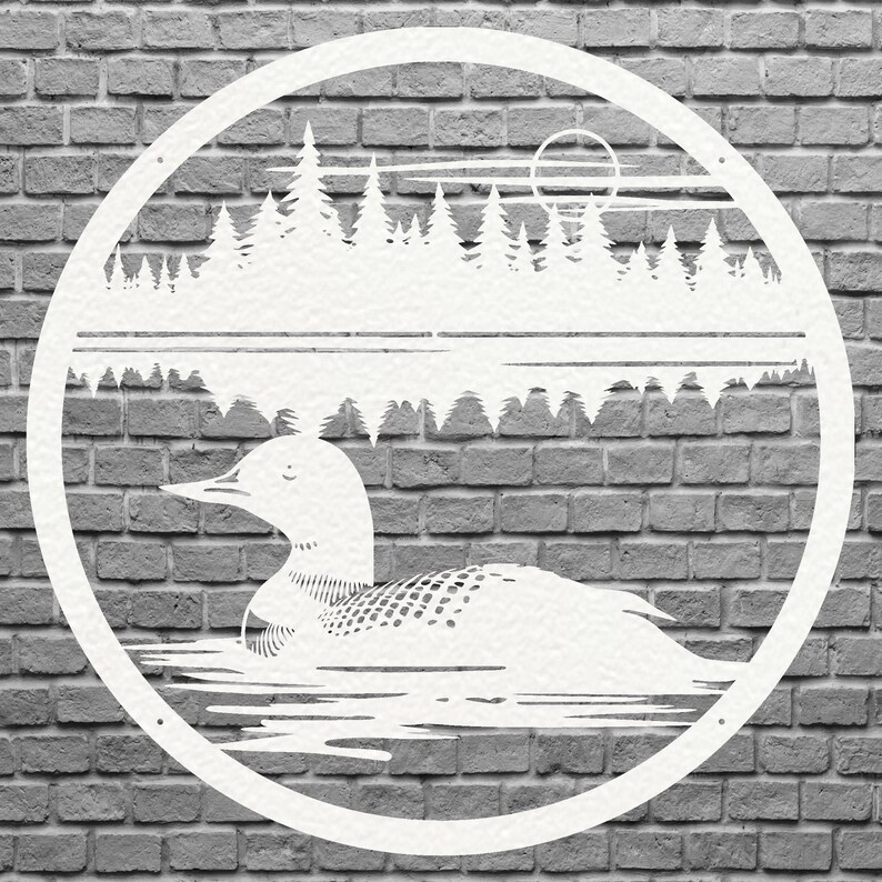 May include: White metal wall art featuring a loon swimming on a lake, with a forest and sun in the background. The design is circular and set against a gray brick wall. The loon has detailed feather patterns.