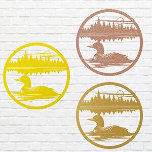 May include: Three round metal wall art pieces in gold, rose gold, and yellow. Each features a loon swimming on water, with a forest and sun design. The art is set within a circular frame, perfect for nature-themed decor.
