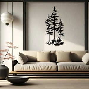 May include: A black metal wall art sculpture of three pine trees with a rocky base. The sculpture is hanging on a white wall in a living room setting with a couch, a lamp, and a vase of flowers.