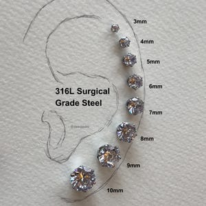 Könnte beinhalten: Eine Größenvergleichstabelle für Ohrringe aus 316L-chirurgischem Stahl mit klaren Zirkonia-Steinen. Die Ohrringe sind in den Größen von 3 mm bis 10 mm dargestellt.