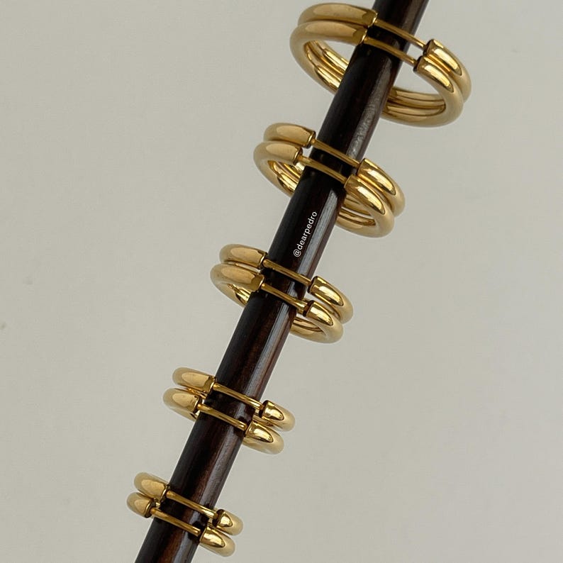Gold 316L stainless steel hinged hoop earrings stacked on rod, minimalist stackable hoops for lobe and cartilage piercings, polished everyday jewelry.