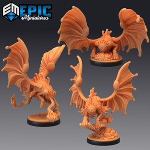 May include: Three miniature fantasy creatures with large, translucent wings and single eyes. The creatures are painted in a light brown colour and are posed in different positions.