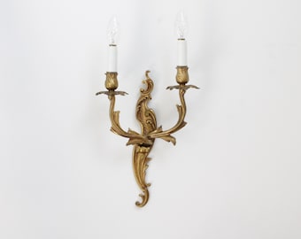 Aplique de pared francés vintage de latón de dos brazos para velas, luminaria estilo Luis XV en tono bronce dorado, lámpara de araña de decoración rococó.