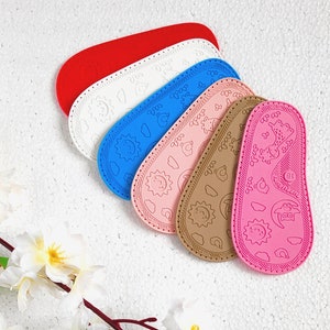 May include: Six colorful silicone baby shoes with different patterns. The shoes are all different colors, including pink, blue, white, and red. The shoes have various designs, including stars, flowers, and animals.