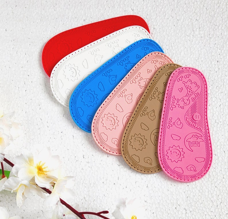 May include: Six colorful silicone baby shoes with different patterns. The shoes are all different colors, including pink, blue, white, and red. The shoes have various designs, including stars, flowers, and animals.