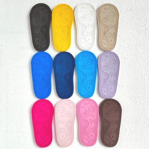 May include: Ten pairs of colorful baby shoes with a sun and moon design. The shoes are made of a soft, flexible material and are perfect for little feet.