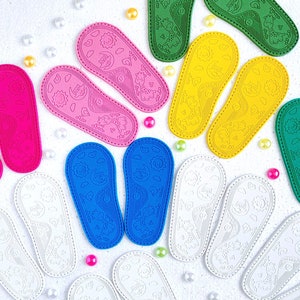 May include: A collection of colorful felt baby shoes with a variety of animal and moon designs. The shoes are in shades of pink, blue, green, yellow, and white.