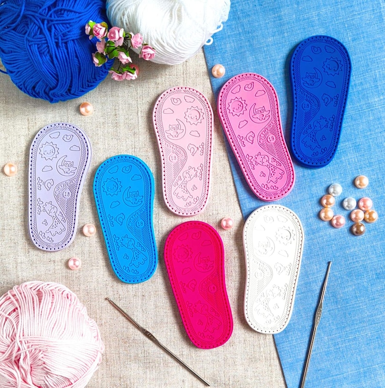 May include: Six colorful fabric shoe soles with a whimsical design of a sun, moon, and owl. The soles are made of a soft, flexible material and are perfect for baby shoes.