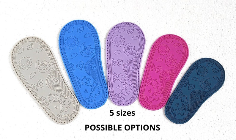 May include: Five pairs of baby shoe soles in different colours: grey, blue, purple, pink, and navy blue. Each sole has a textured design with a sun, moon, clouds, and an owl. The text "5 sizes" and "POSSIBLE OPTIONS" is printed below the soles.