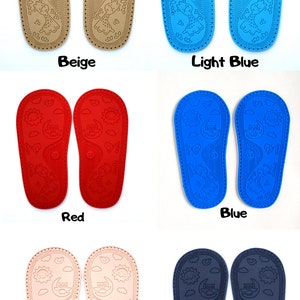 May include: Six pairs of baby shoe soles in different colors: beige, light blue, red, blue, light pink, and dark blue. Each sole has a textured design with a giraffe, sun, moon, and owl.