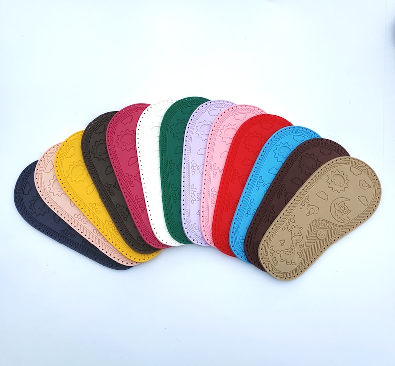 May include: A set of 12 colorful fabric shoe soles with various designs, including a sun, clouds, and a giraffe. The soles are made of a soft, flexible material and are perfect for adding a touch of personality to any pair of shoes.