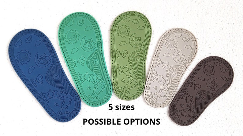 May include: Five pairs of baby shoe soles in different colours: blue, green, beige, and brown. Each sole has a pattern of a sun, moon, owl, and giraffe. The text "5 sizes" and "POSSIBLE OPTIONS" is printed below the soles.